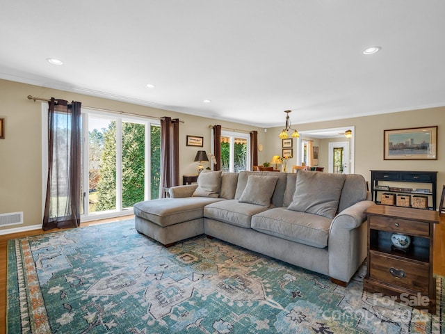 living area with baseboards, visible vents, ornamental molding, wood finished floors, and recessed lighting