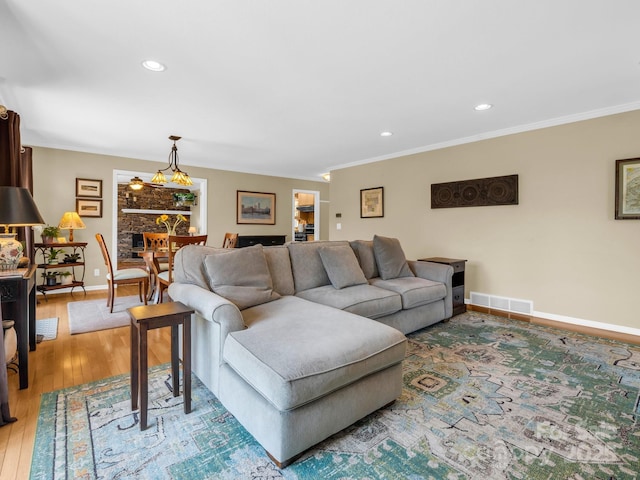 living area with recessed lighting, visible vents, baseboards, light wood-style floors, and ornamental molding