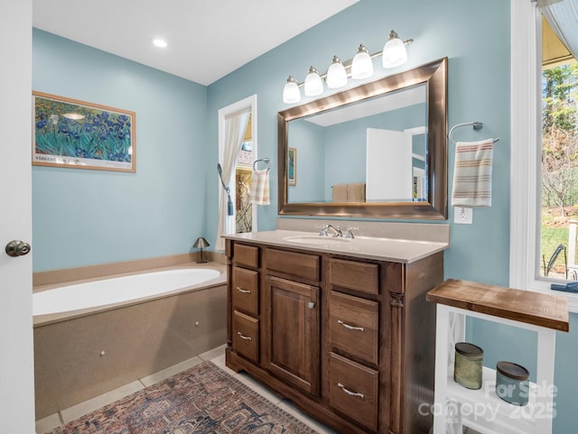 bathroom with a garden tub, vanity, and tile patterned floors