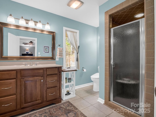 bathroom featuring toilet, a stall shower, ceiling fan, vanity, and tile patterned floors