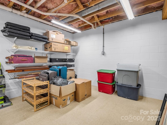 unfinished basement featuring concrete block wall and tile patterned floors