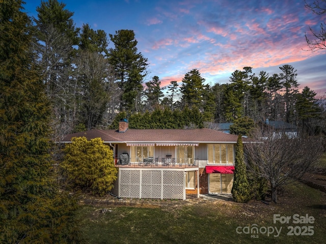 rear view of property with a deck and a chimney