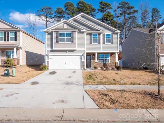 craftsman house with a garage, a front yard, stone siding, and driveway