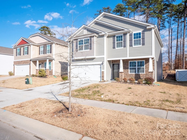 view of front of home featuring a garage, a front yard, stone siding, and concrete driveway