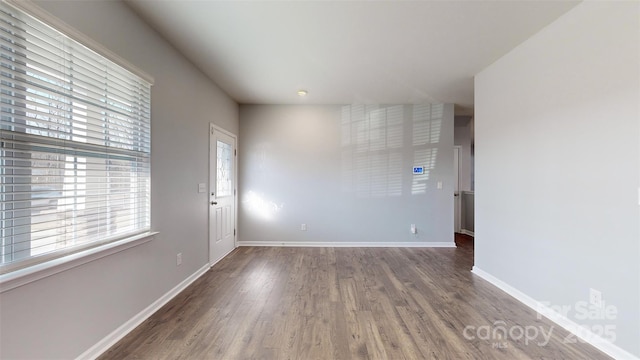 empty room featuring baseboards and wood finished floors