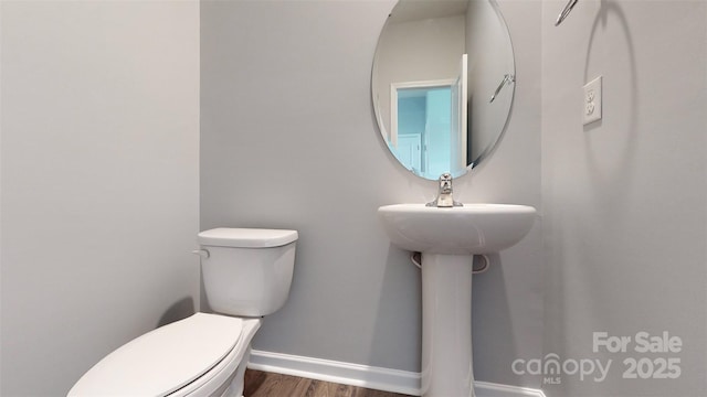 bathroom featuring wood finished floors, toilet, and baseboards