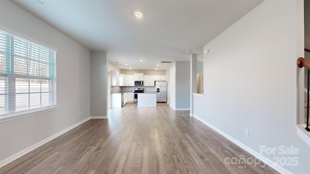 unfurnished living room featuring recessed lighting, baseboards, visible vents, and light wood finished floors