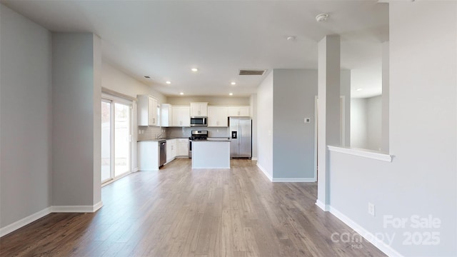 unfurnished living room featuring recessed lighting, baseboards, visible vents, and light wood finished floors