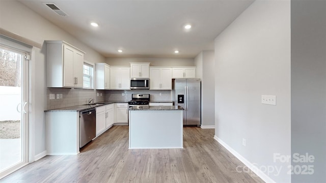 kitchen with visible vents, appliances with stainless steel finishes, backsplash, and white cabinetry