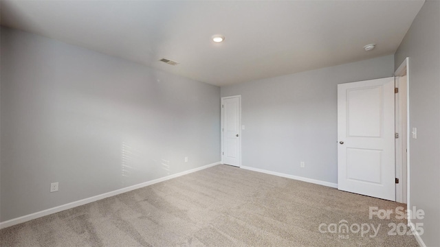 unfurnished room with baseboards, visible vents, and carpet flooring