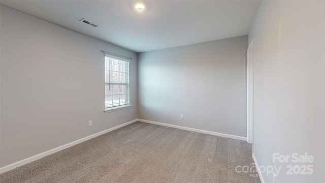 carpeted spare room featuring visible vents and baseboards