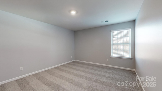 unfurnished room featuring light carpet, visible vents, and baseboards