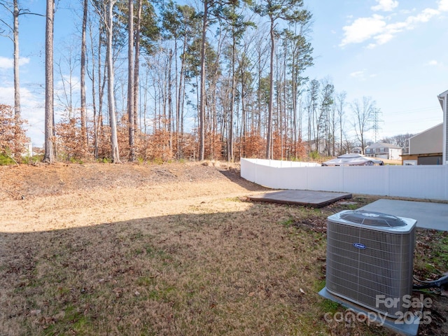 view of yard with central AC and fence