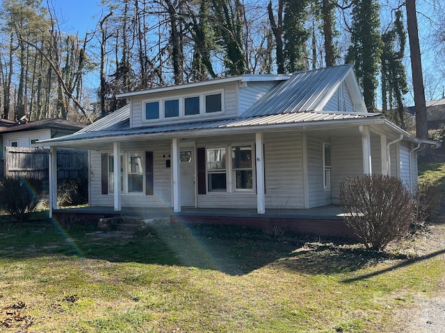 view of front of house with metal roof, a porch, and a front lawn