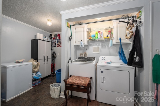 washroom with crown molding, visible vents, cabinet space, a textured ceiling, and washer and dryer