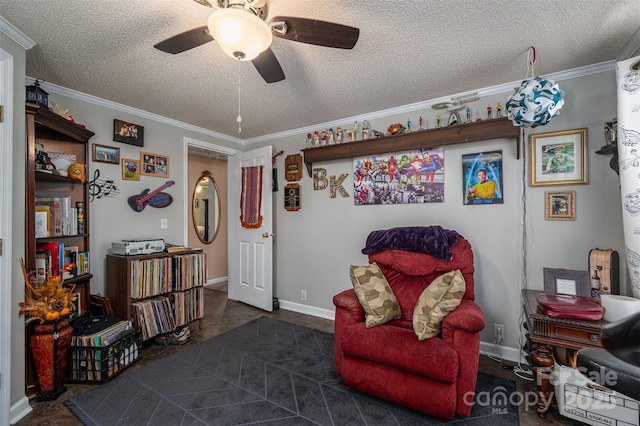 sitting room featuring a ceiling fan, crown molding, a textured ceiling, and baseboards