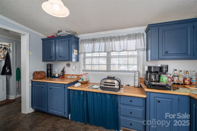 kitchen featuring a textured ceiling, blue cabinetry, washer / dryer, and crown molding