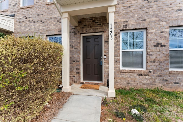 entrance to property featuring brick siding