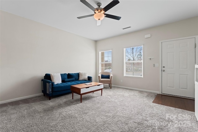 living room with visible vents, baseboards, ceiling fan, and carpet floors