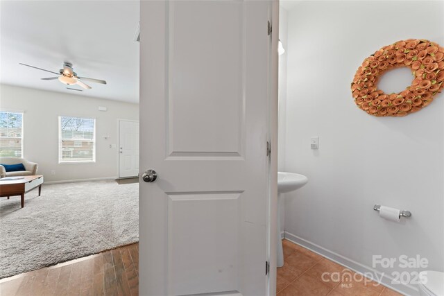 bathroom with baseboards, ceiling fan, and wood finished floors