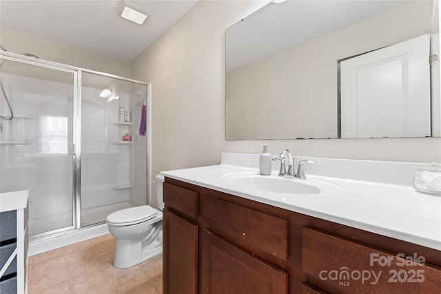 bathroom featuring vanity, a shower stall, toilet, and tile patterned floors