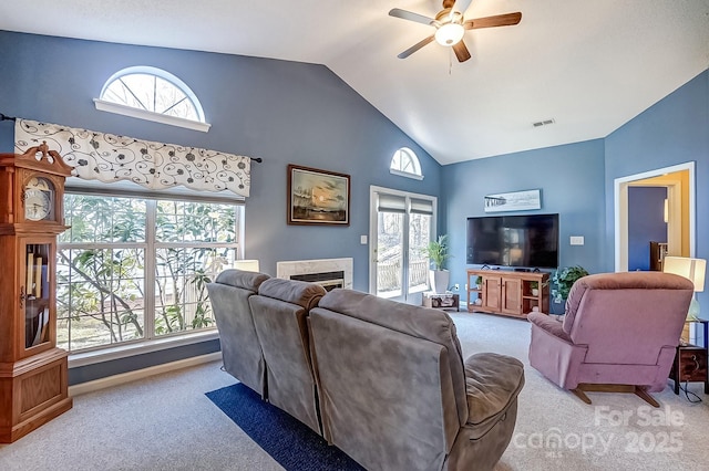 living area featuring visible vents, ceiling fan, carpet, a fireplace, and high vaulted ceiling