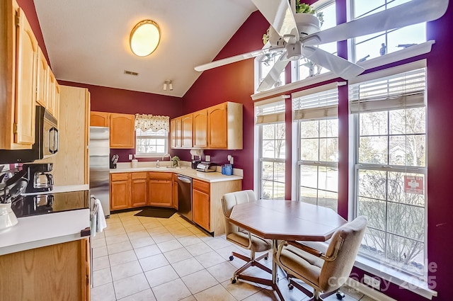 kitchen with light tile patterned floors, ceiling fan, stainless steel appliances, vaulted ceiling, and light countertops