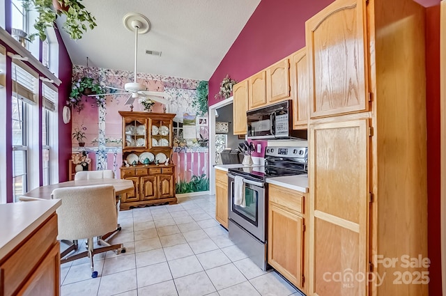 kitchen featuring wallpapered walls, lofted ceiling, stainless steel electric range, light countertops, and black microwave