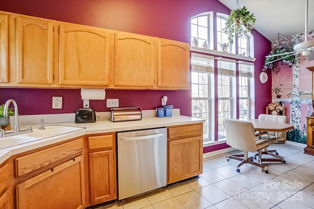 kitchen featuring light tile patterned floors, a sink, vaulted ceiling, light countertops, and dishwasher