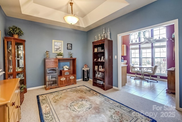 interior space featuring light carpet, light tile patterned floors, baseboards, and a tray ceiling