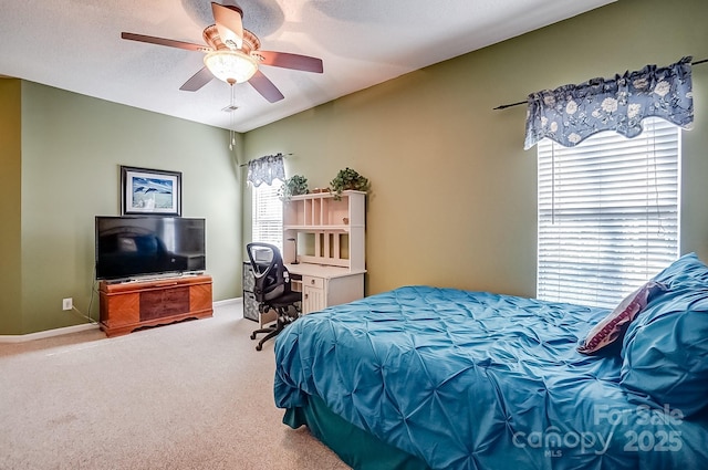 bedroom featuring ceiling fan, carpet floors, multiple windows, and baseboards