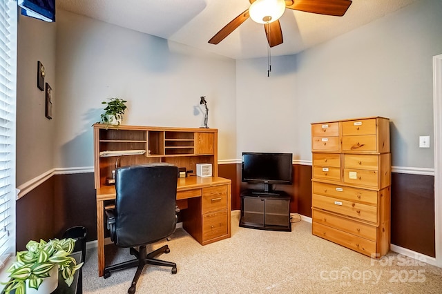 office space featuring light carpet, baseboards, and a ceiling fan