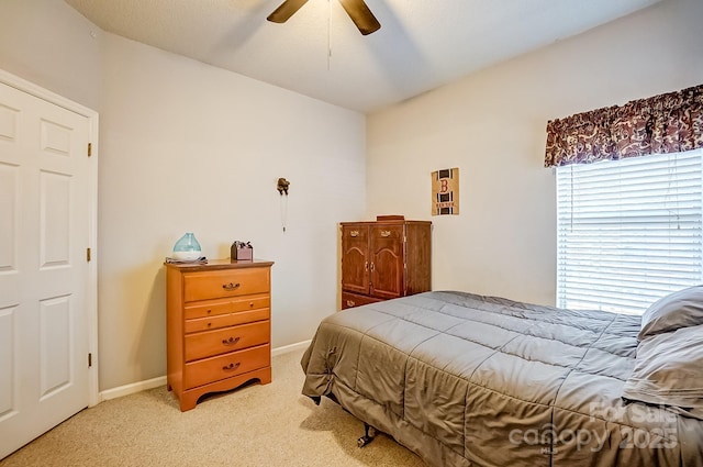 bedroom with baseboards, a ceiling fan, and light colored carpet