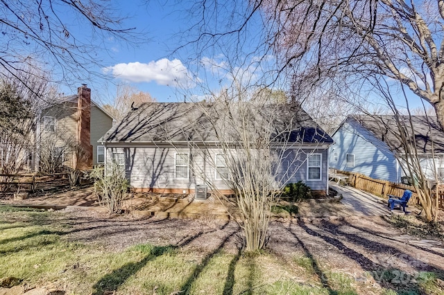 back of house with driveway and fence