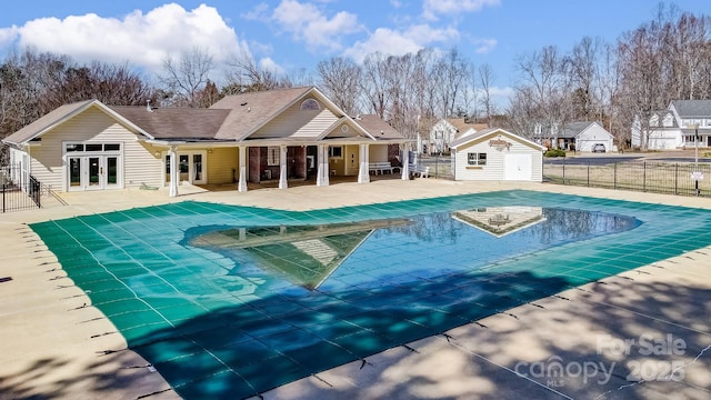 pool with french doors, a patio area, fence, a residential view, and an outdoor structure