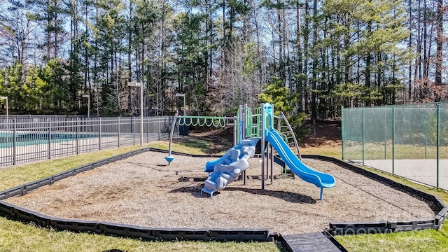 community playground featuring fence and a fenced in pool