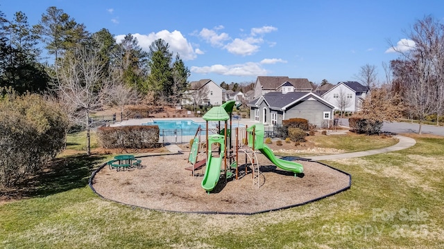 community jungle gym with a residential view and a yard