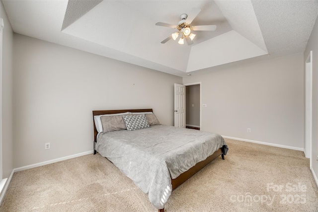 bedroom with carpet flooring, a raised ceiling, and baseboards