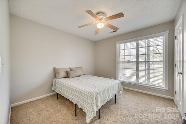 bedroom featuring visible vents, baseboards, a ceiling fan, carpet, and a textured ceiling