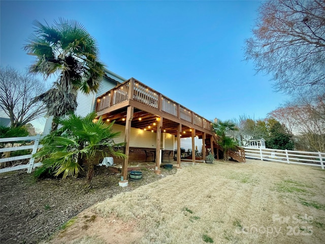 rear view of house featuring stairway, fence, and a deck