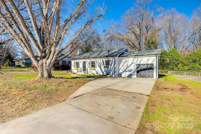 ranch-style house with driveway, a garage, a chimney, and a front lawn