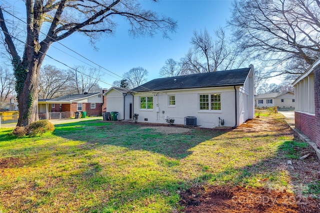 rear view of property featuring brick siding, a yard, and central AC unit