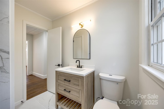 bathroom with marble finish floor, crown molding, vanity, and toilet