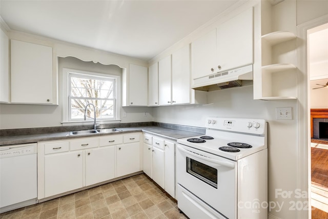 kitchen with white appliances, dark countertops, a sink, and under cabinet range hood