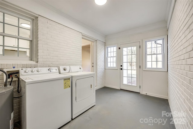 washroom featuring washing machine and dryer, brick wall, laundry area, water heater, and crown molding