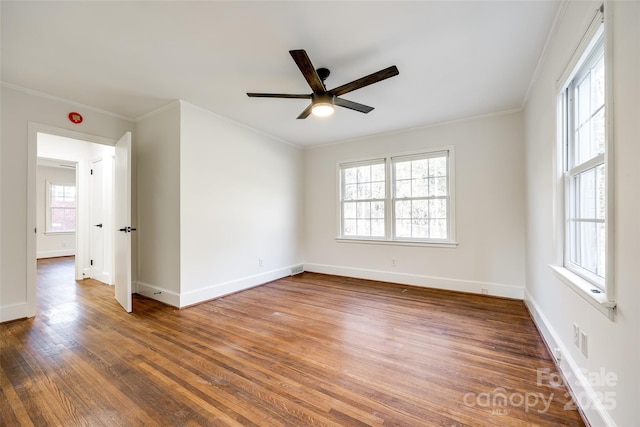 unfurnished room with a ceiling fan, crown molding, baseboards, and wood finished floors