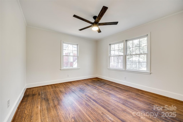 empty room with baseboards, ornamental molding, ceiling fan, and wood finished floors