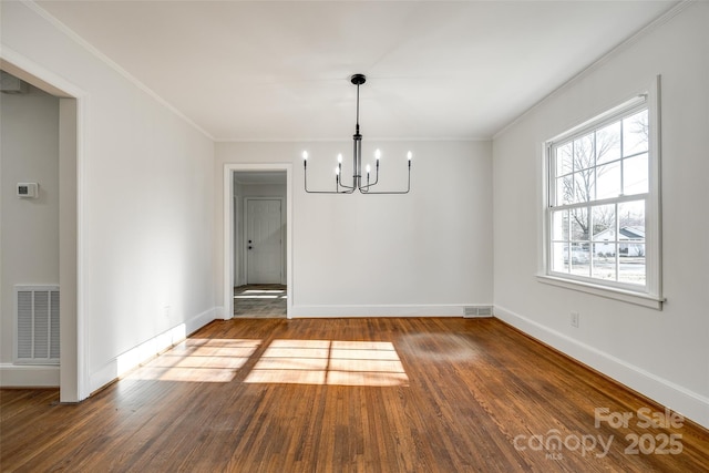 unfurnished dining area featuring baseboards, wood finished floors, visible vents, and crown molding