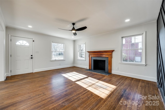 unfurnished living room featuring dark wood-style floors, plenty of natural light, and a fireplace