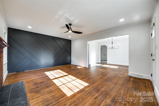 unfurnished room featuring ceiling fan with notable chandelier, dark wood-style flooring, visible vents, and crown molding